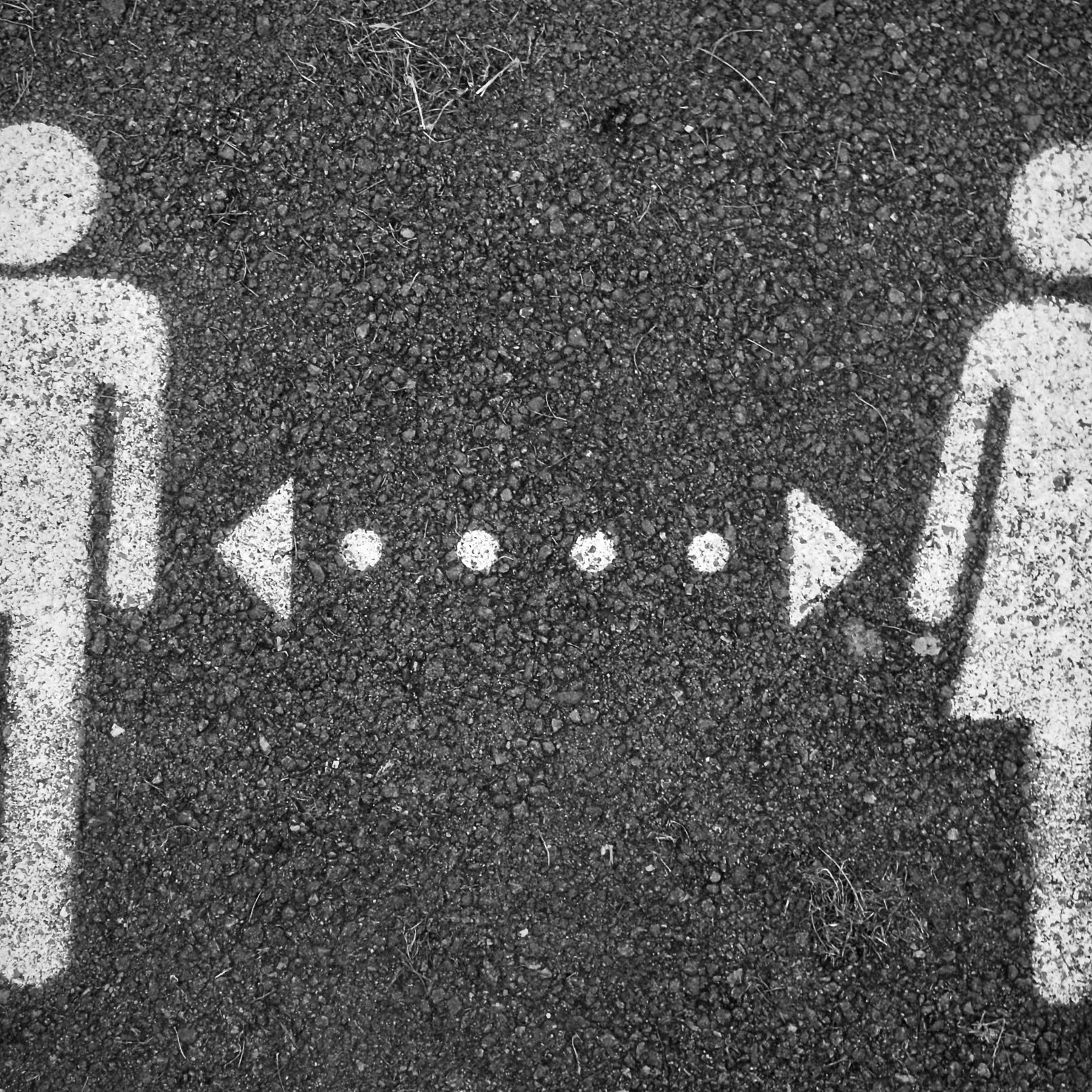 Symbol eines Mannes (links) und einer Frau (rechts), mit Kreide gemalt, dazwischen eine gepunktete Linie mit jeweils einem Pfeil nach rechts und links.