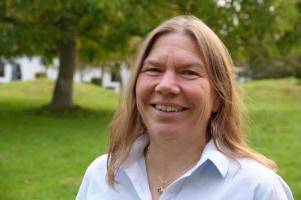 Eine Frau in einem grünen Park mit Baum.