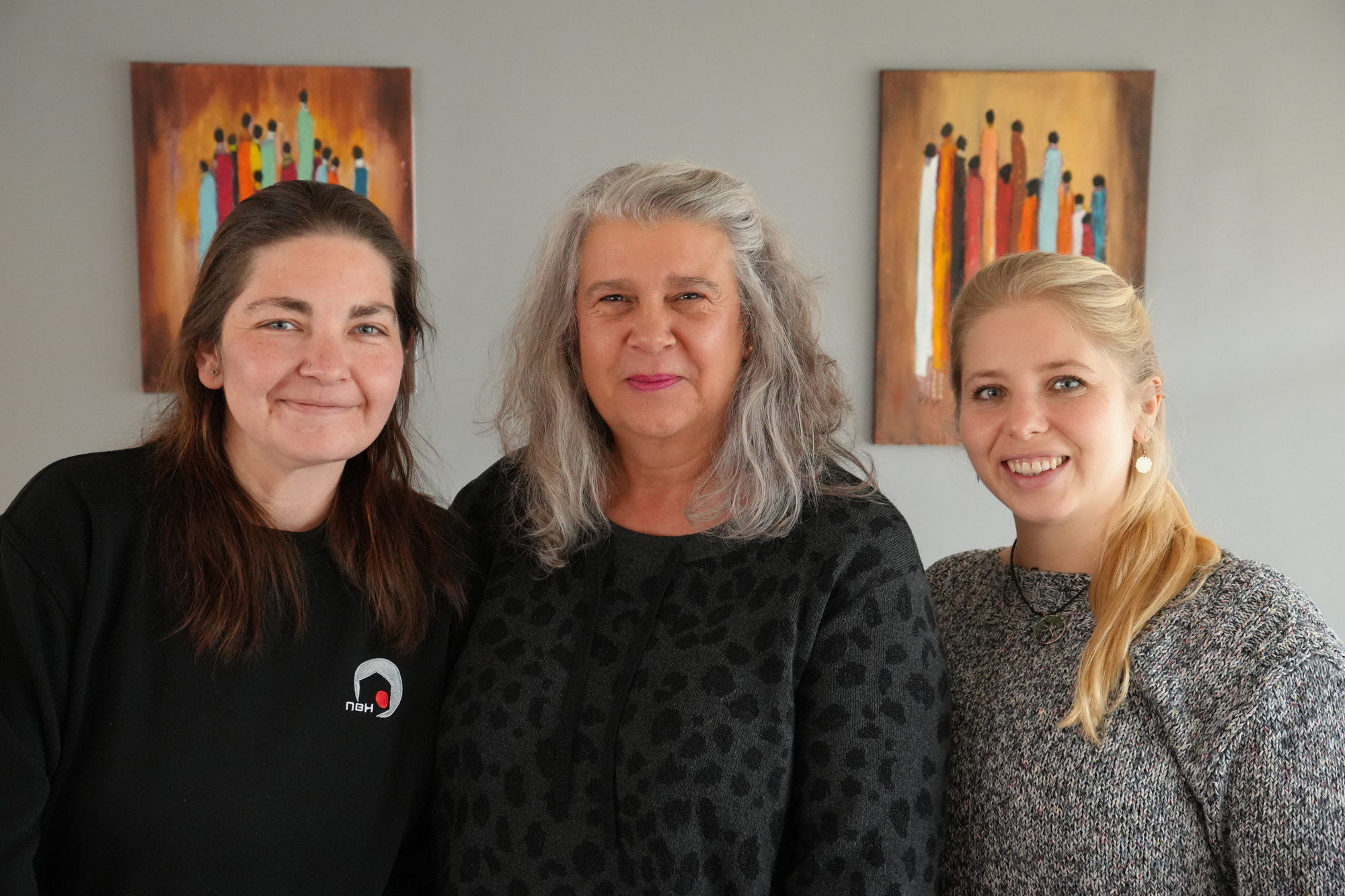 Drei Frauen schauen in die Kamera.