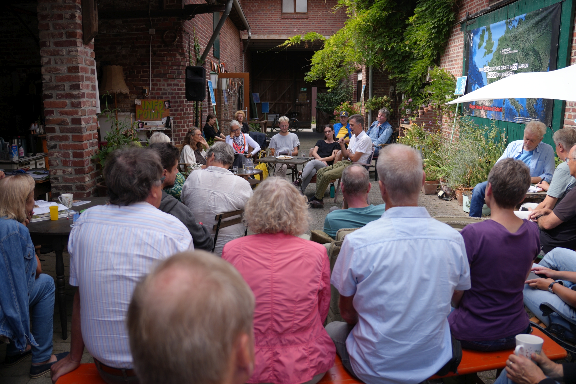 Menschen diskutieren in einem Hof.
