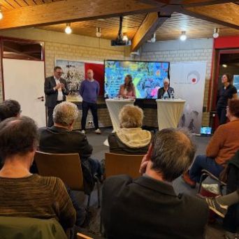 Blick auf das Publikum und die Teilnemenden der Podiumsdiskussion